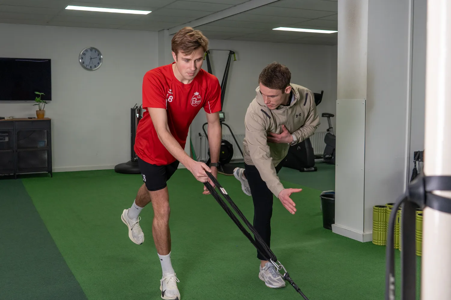Sportrevalidatie met knieoefening aan weerstandsband onder begeleiding van Démen Roumen